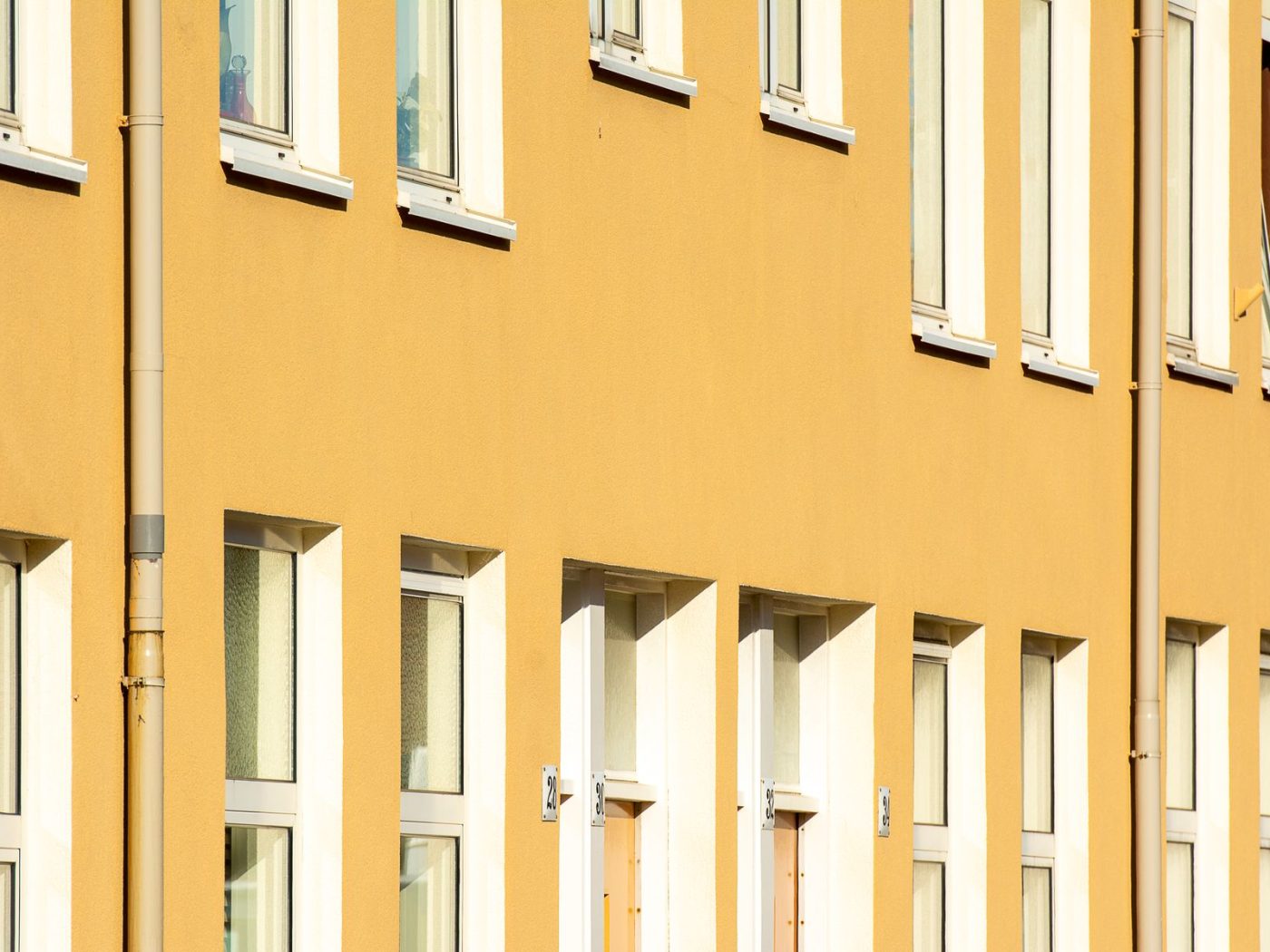 Gelb gestrichene Hausfassade mit weißen Fenstern